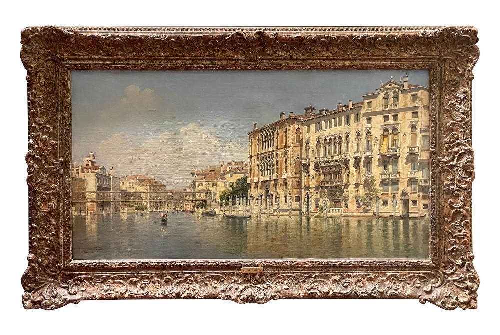 A 19th-century oil painting on canvas depicting historic Venetian buildings along a canal, framed within an ornate carved gilded border.