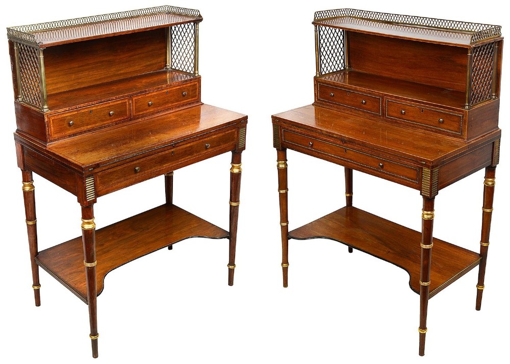 A pair of Regency period rosewood bonheur du jour writing desks featuring brass galleries, lattice side panels, upper drawers, and turned legs with lower shelves.