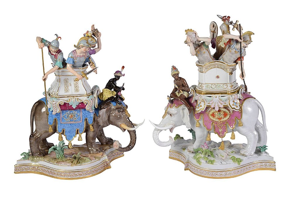 A pair of elaborate 19th-century Meissen porcelain sculptures depicting war elephants with armed soldiers and attendants on gilded bases.
