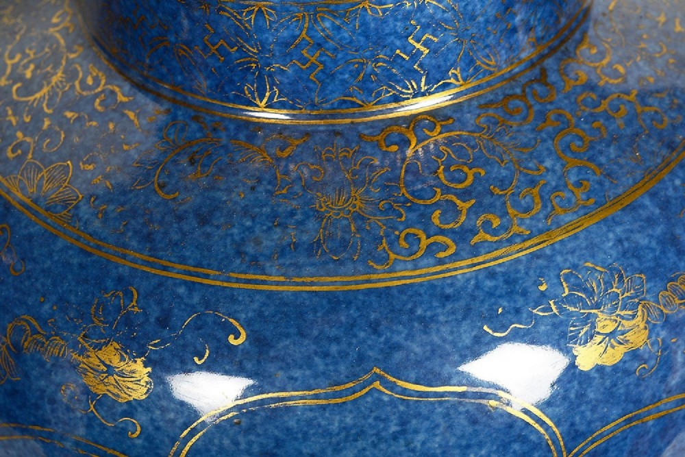 A pair of 19th-century powder blue porcelain baluster vases with gilt floral panels, domed covers, and decorative ormolu bases. View IV