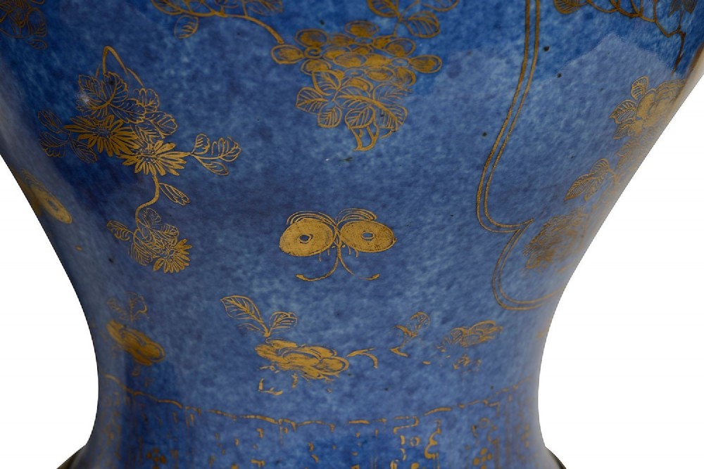 A pair of 19th-century powder blue porcelain baluster vases with gilt floral panels, domed covers, and decorative ormolu bases. View V