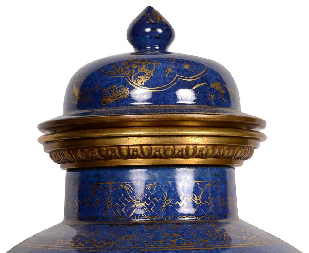 A pair of 19th-century powder blue porcelain baluster vases with gilt floral panels, domed covers, and decorative ormolu bases. View VII