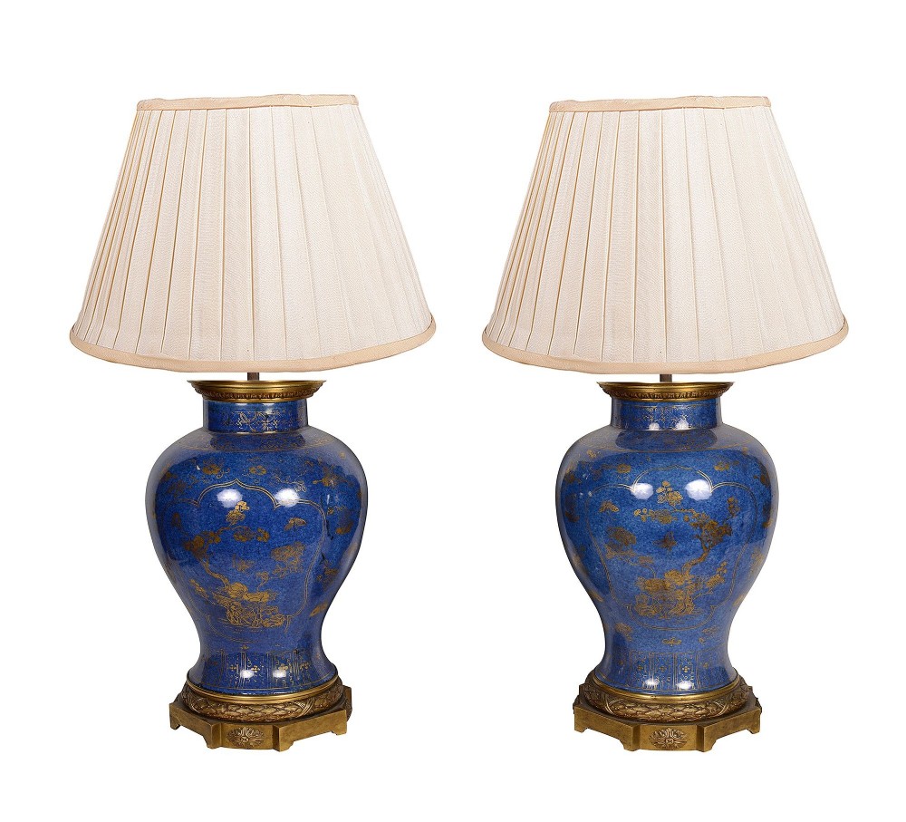A pair of 19th-century powder blue porcelain baluster vases with gilt floral panels, domed covers, and decorative ormolu bases. View VIII