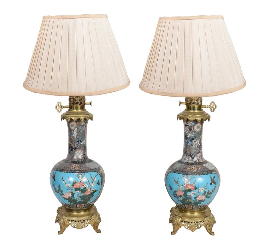 A pair of late nineteenth-century Japanese cloisonne table lamps with turquoise enamel floral bases, brass mounts, and cream pleated lampshades.