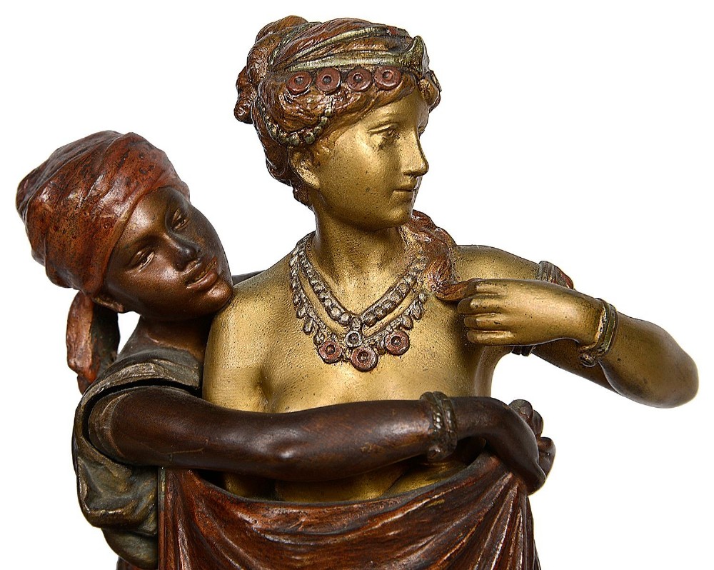 Cold painted bronze sculpture depicting a semi-nude woman and an attendant standing upon a carpet-patterned surface mounted on an alabaster base. View III
