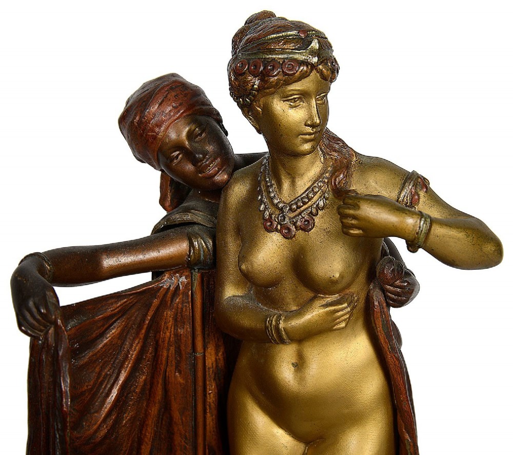 Cold painted bronze sculpture depicting a semi-nude woman and an attendant standing upon a carpet-patterned surface mounted on an alabaster base. View VIII