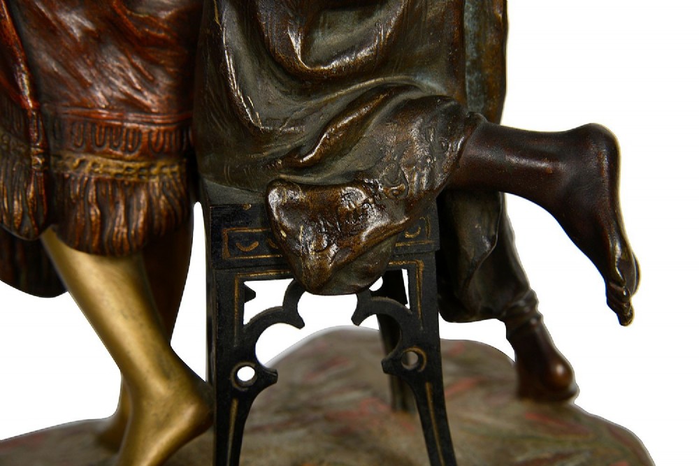 Cold painted bronze sculpture depicting a semi-nude woman and an attendant standing upon a carpet-patterned surface mounted on an alabaster base. View IX