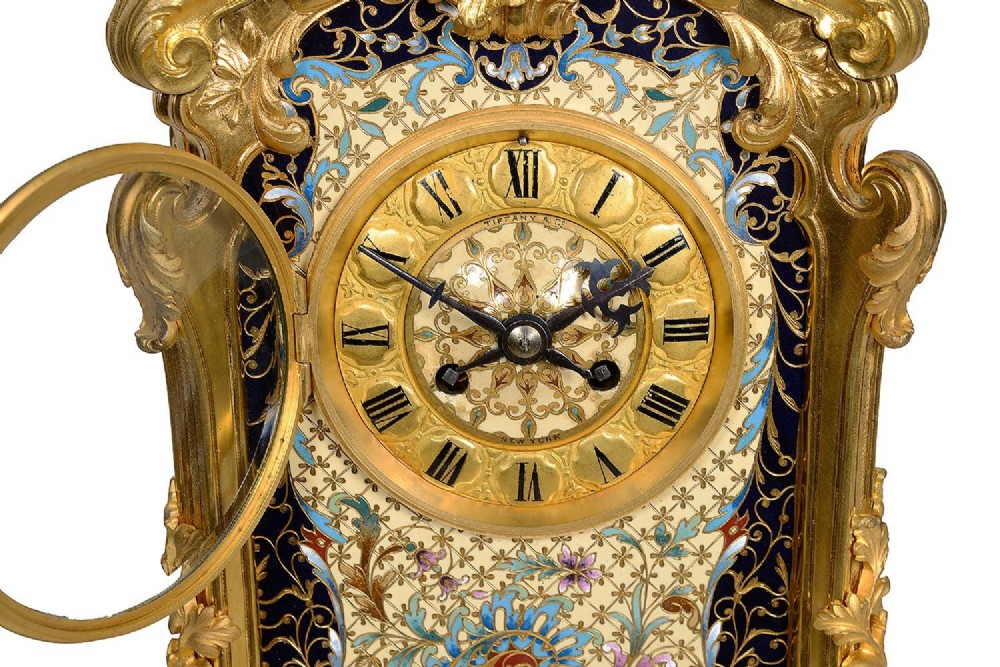 A 19th-century French Louis XVI style gilt bronze mantel clock decorated with multi-coloured enamel scrollwork and topped with twin cherub figures. View II