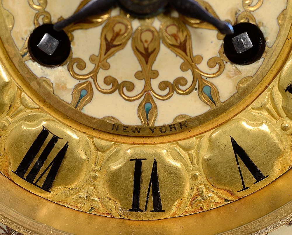 A 19th-century French Louis XVI style gilt bronze mantel clock decorated with multi-coloured enamel scrollwork and topped with twin cherub figures. View IV