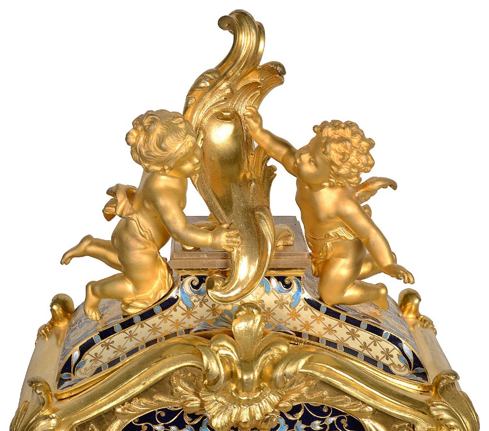A 19th-century French Louis XVI style gilt bronze mantel clock decorated with multi-coloured enamel scrollwork and topped with twin cherub figures. View VII