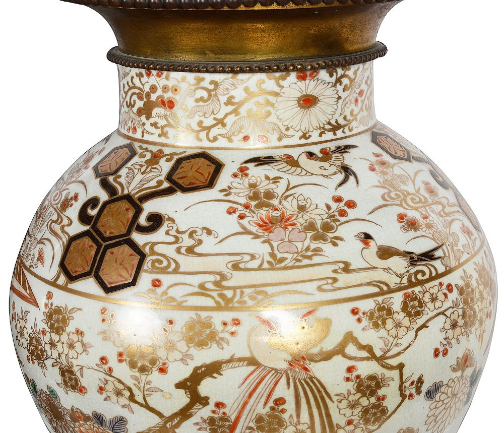 Pair of Japanese Arita Imari porcelain lidded vases featuring painted figures under umbrellas, standing on bronze bases with standing figure finials. View VII