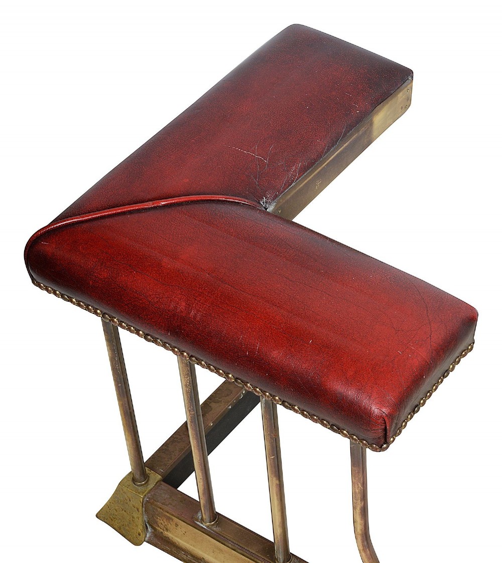 Late 19th-century brass club fender featuring twin red leather corner seats with stud trim and vertical brass spindles. View III
