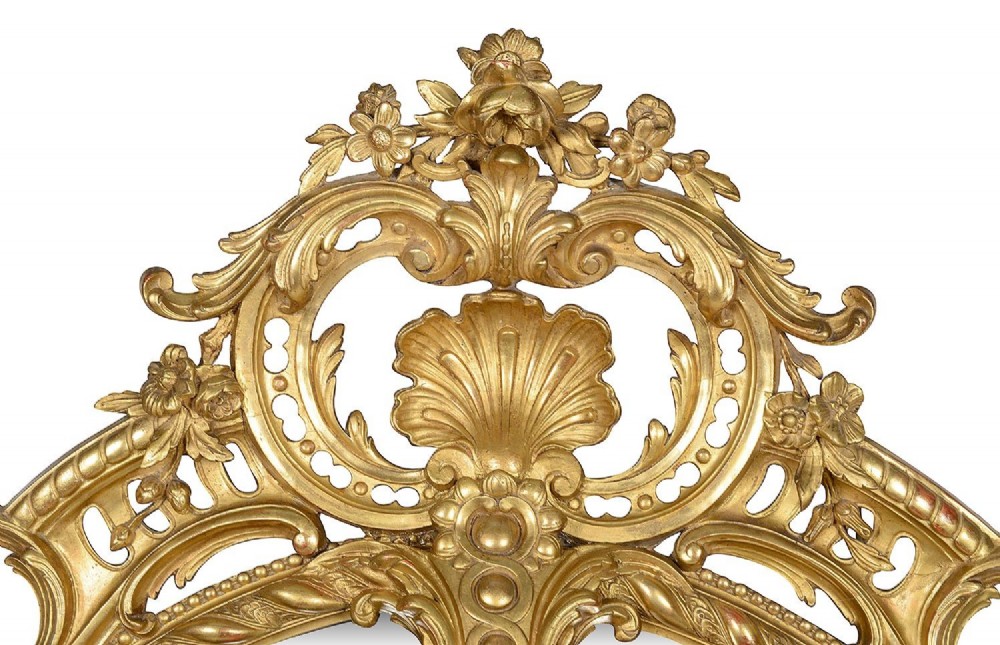 An ornate 19th-century oval wall mirror featuring a gilded wood and gesso frame with pierced scrollwork, shell cresting, and floral motifs. View II