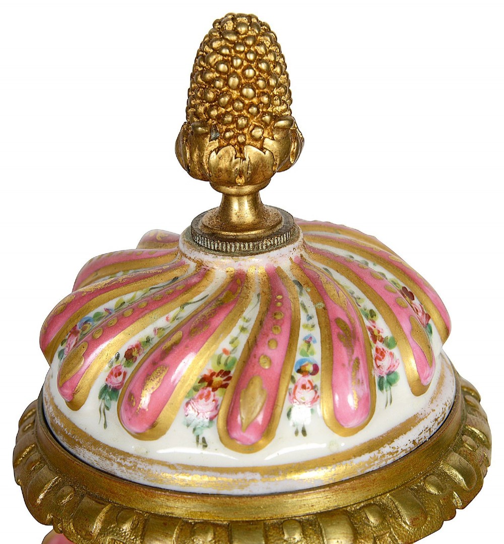 A pair of 19th-century French Sevres style pink and white porcelain lidded vases featuring hand-painted floral stripes and gilt decoration on square bases. View VI