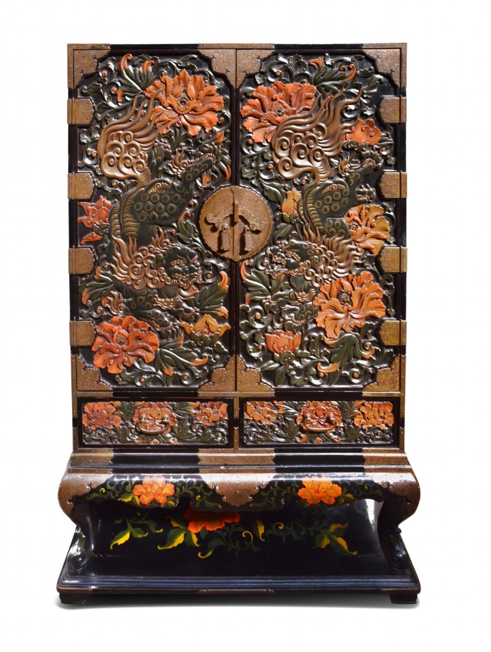 A late nineteenth-century black and polychrome carved lacquer cabinet featuring relief peony and dragon motifs, fitted brass hardware, and a matching stand base.