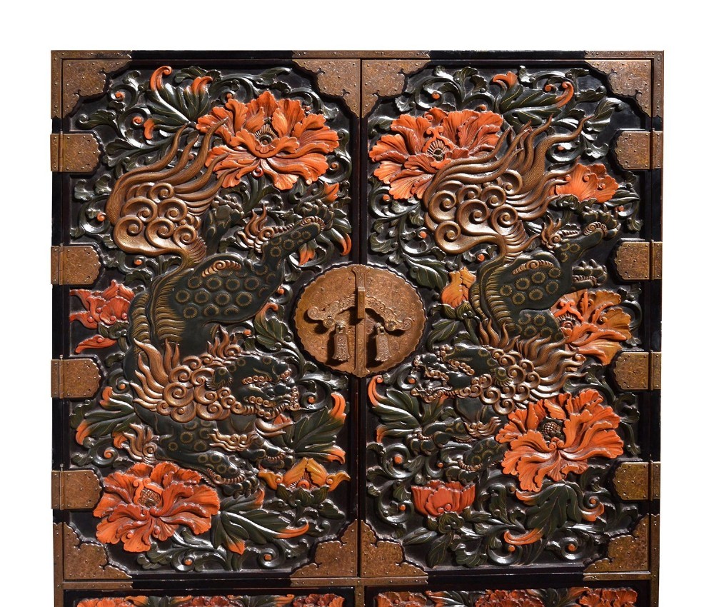 A late nineteenth-century black and polychrome carved lacquer cabinet featuring relief peony and dragon motifs, fitted brass hardware, and a matching stand base. View II
