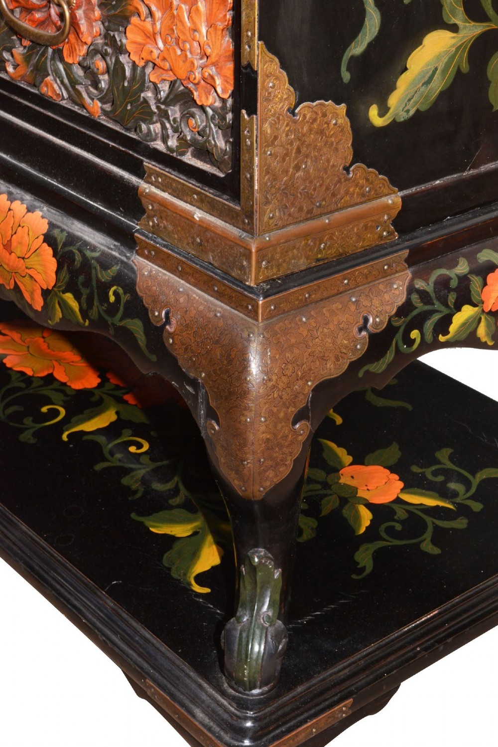 A late nineteenth-century black and polychrome carved lacquer cabinet featuring relief peony and dragon motifs, fitted brass hardware, and a matching stand base. View X