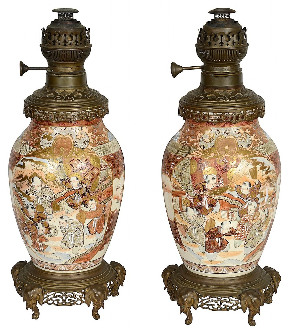 A pair of 19th-century Japanese Satsuma porcelain table lamps with brass mounts, elephant-head tripod bases, and pleated cream silk lampshades. View III