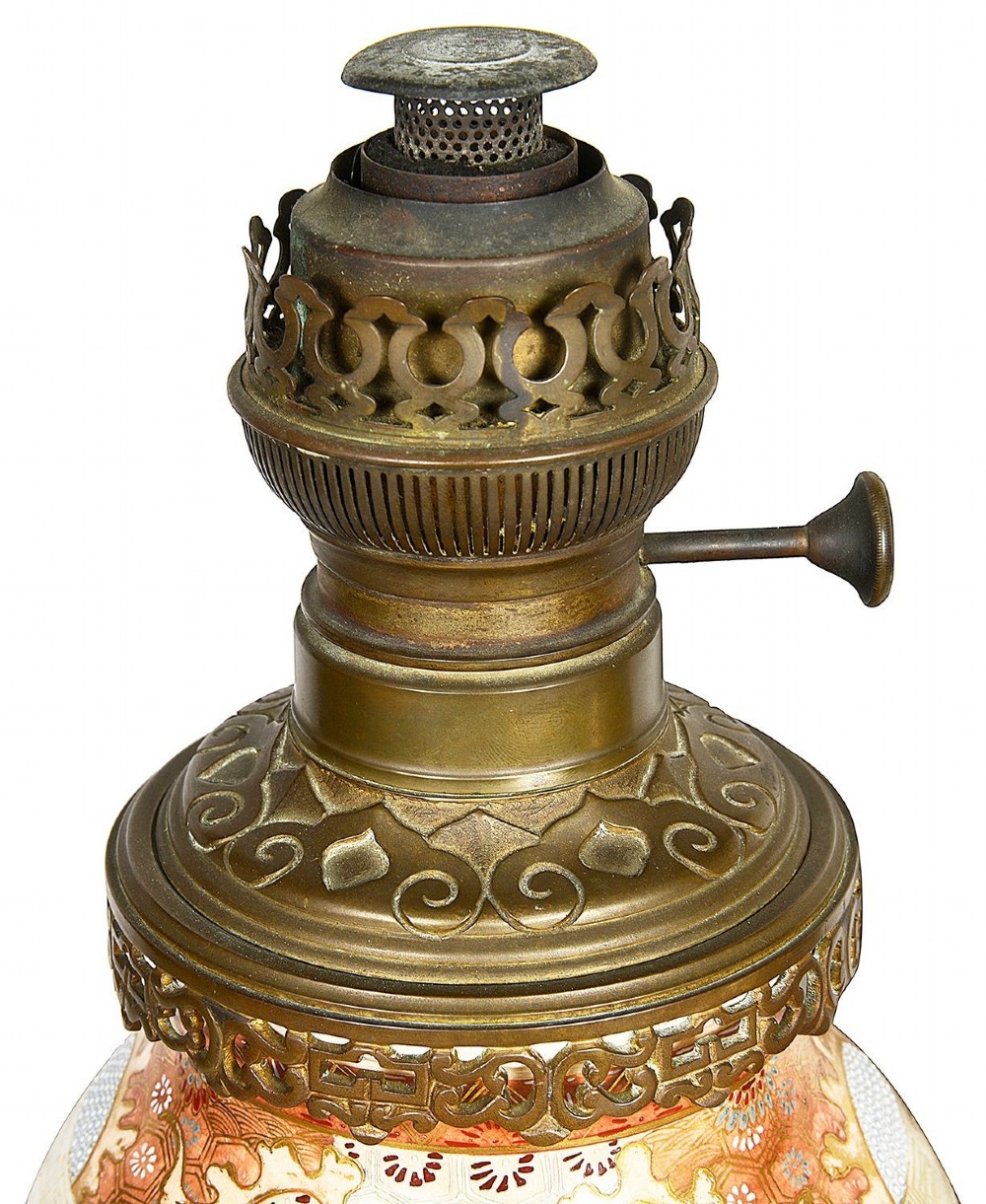 A pair of 19th-century Japanese Satsuma porcelain table lamps with brass mounts, elephant-head tripod bases, and pleated cream silk lampshades. View IV