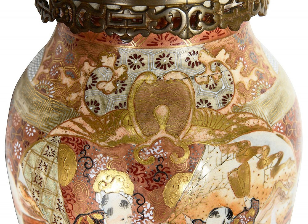 A pair of 19th-century Japanese Satsuma porcelain table lamps with brass mounts, elephant-head tripod bases, and pleated cream silk lampshades. View V