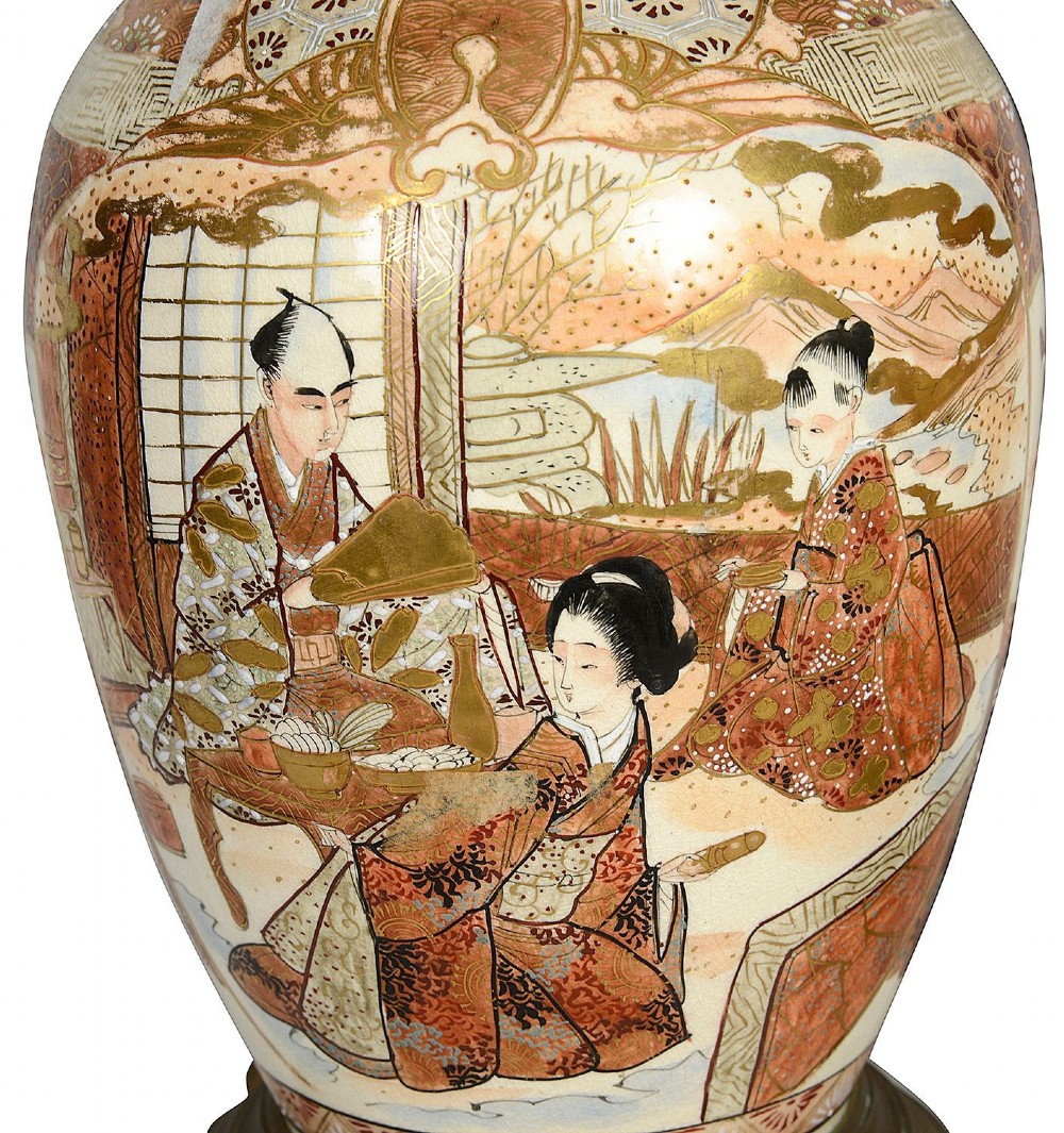 A pair of 19th-century Japanese Satsuma porcelain table lamps with brass mounts, elephant-head tripod bases, and pleated cream silk lampshades. View VI