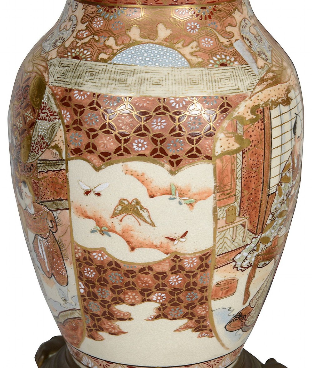 A pair of 19th-century Japanese Satsuma porcelain table lamps with brass mounts, elephant-head tripod bases, and pleated cream silk lampshades. View VII