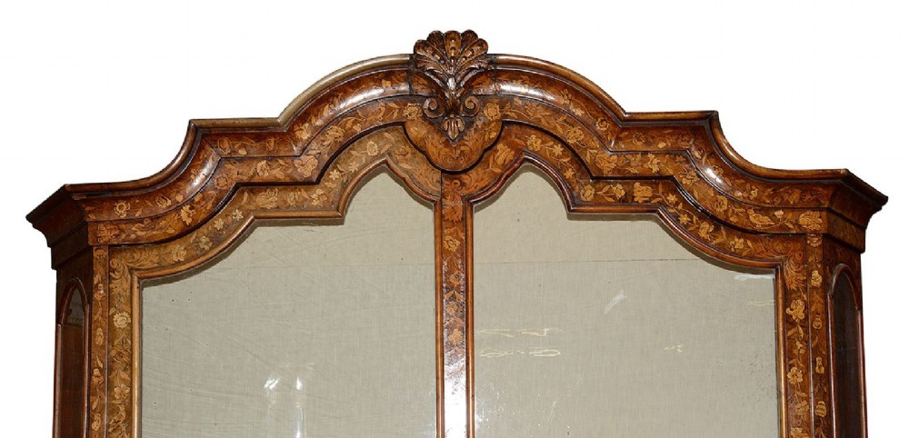 An 18th-century Dutch marquetry vitrine featuring detailed floral wood inlay, two glazed upper doors, a shaped bonnet top with carved shell cresting, a bombe three-drawer base, and claw-and-ball feet. View VII
