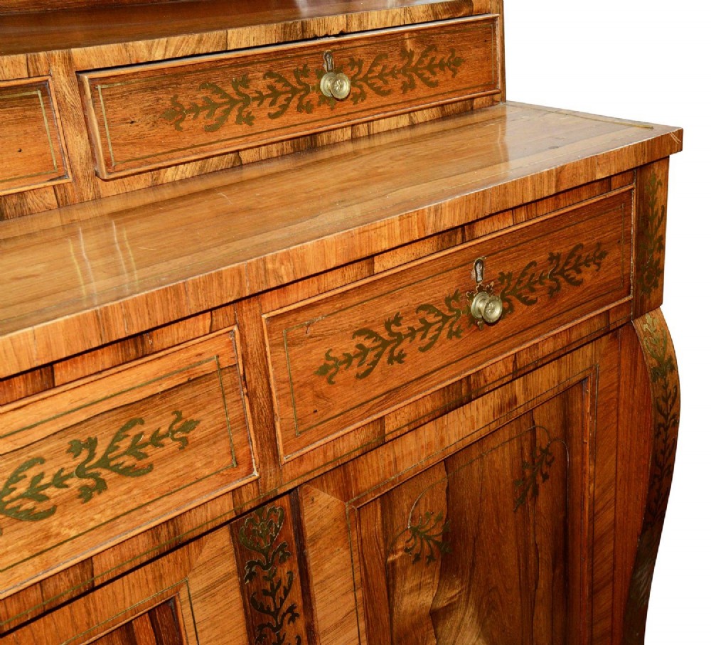 A Regency period warm brown timber chiffonier featuring intricate brass scrollwork inlay, a raised shelf gallery with two small drawers, and a two-door lower cabinet. View VI