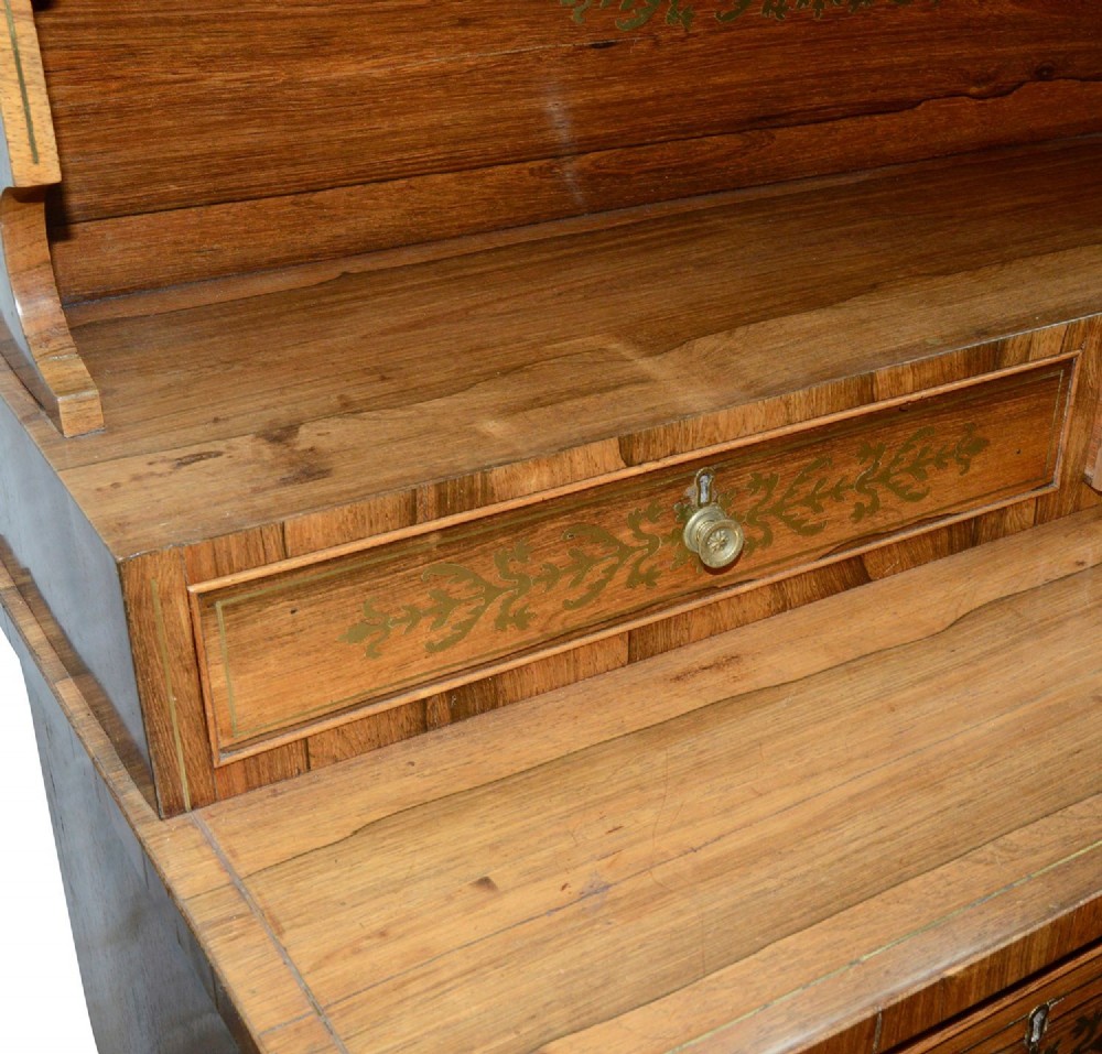 A Regency period warm brown timber chiffonier featuring intricate brass scrollwork inlay, a raised shelf gallery with two small drawers, and a two-door lower cabinet. View VII