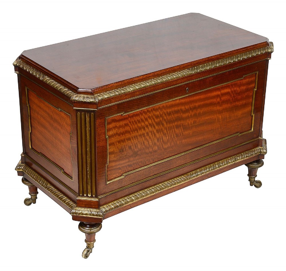 A rectangular French Louis XVI style mahogany cellarette featuring fluted corner columns, ornate brass egg-and-dart moulding, and tapered turned legs with castors.