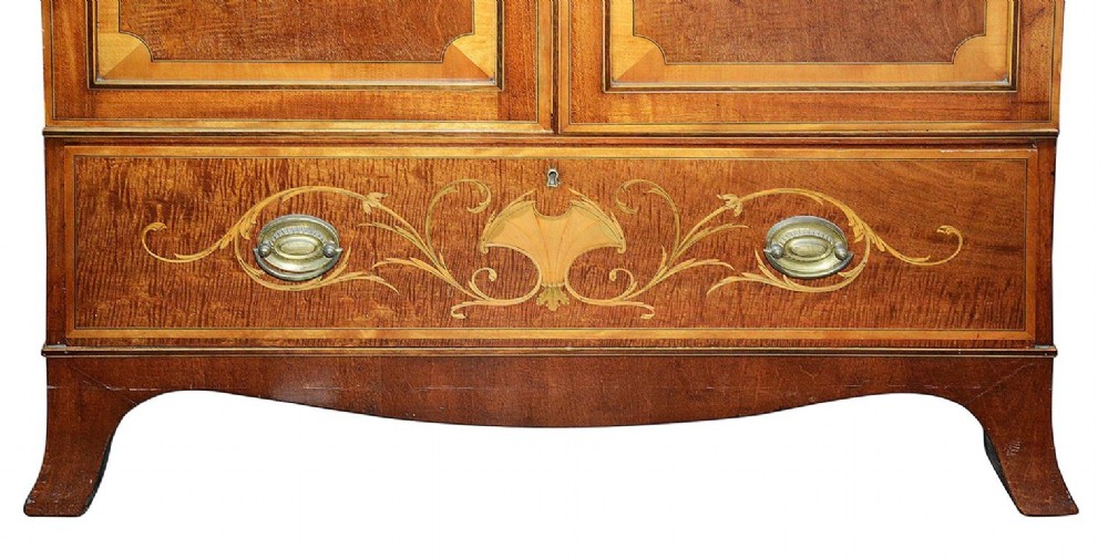 An Edwardian mahogany two door wardrobe featuring intricate neoclassical satinwood inlay on the door panels and lower drawer. View VI