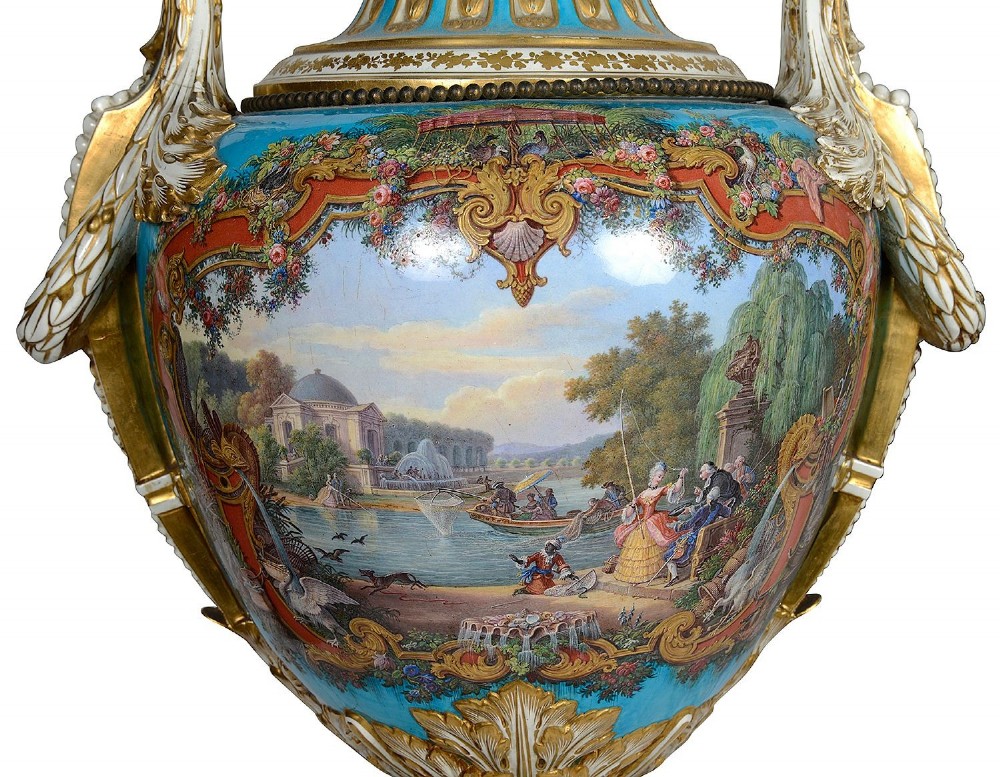 A pair of turquoise blue Sevres-style porcelain urns featuring hand-painted pastoral scenes, gilded scroll handles, and pineapple finials on square metal bases. View II