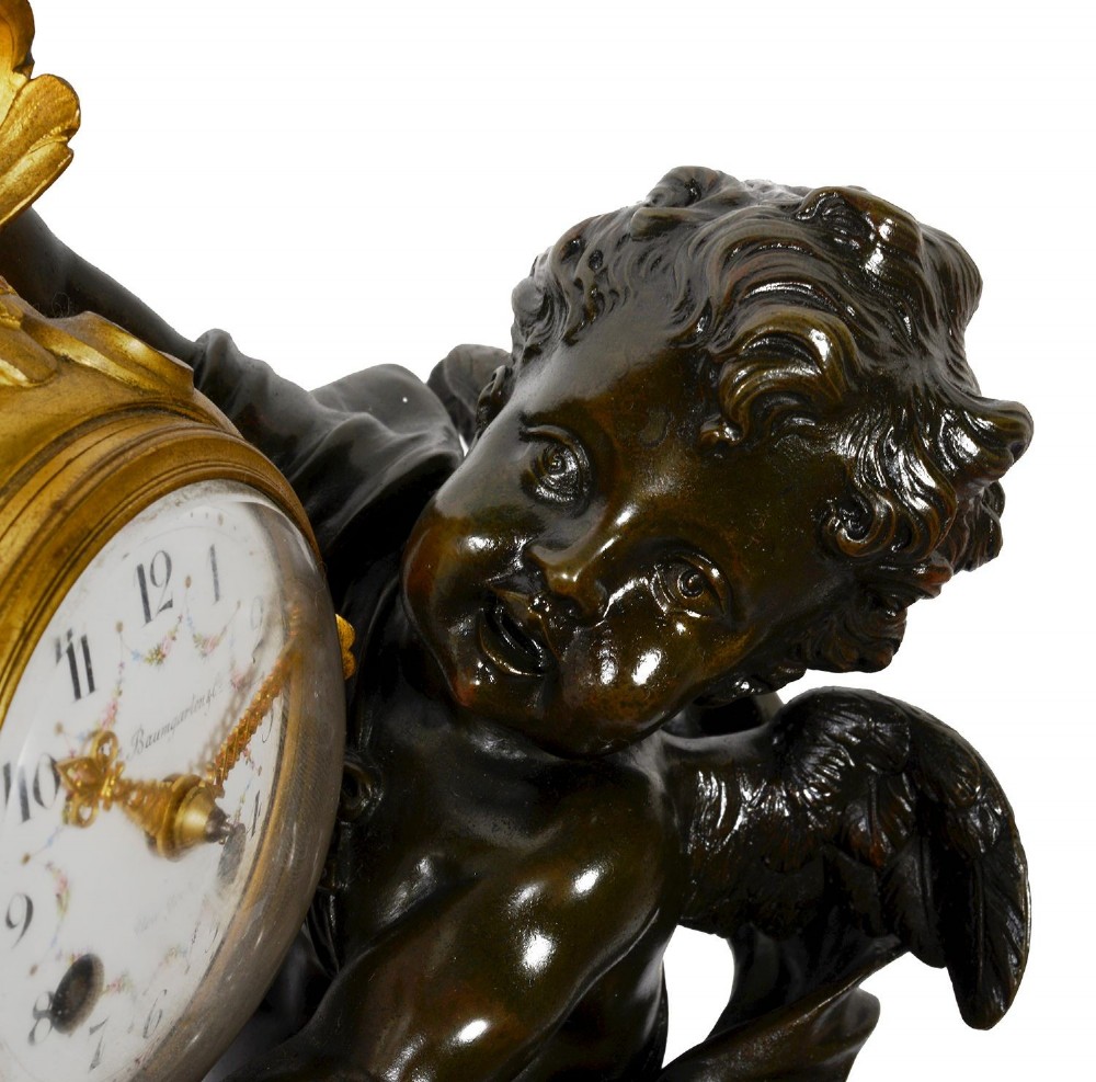 A 19th-century French classical mantel clock featuring a dark patinated bronze cherub seated on an ornate gilded scroll base holding a gilt-framed dial. View VII