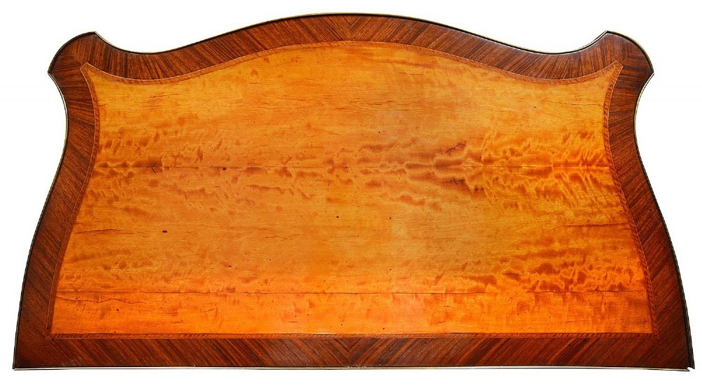 A pair of early 20th-century serpentine mahogany and satinwood commodes with oval central inlays and brass feet. View VII