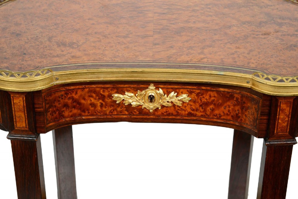 A Louis XVI style kidney-shaped two-tier side table featuring burr walnut veneer, a pierced brass gallery, and gilt-bronze mounts. View VI