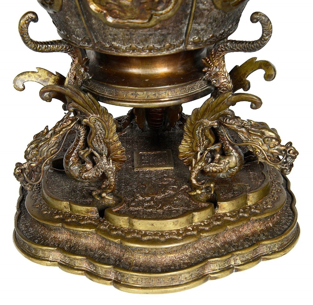A pair of ornate antique Japanese Meiji period bronze lidded censers featuring dragon bases, relief panels, and shishi lion finials. View V