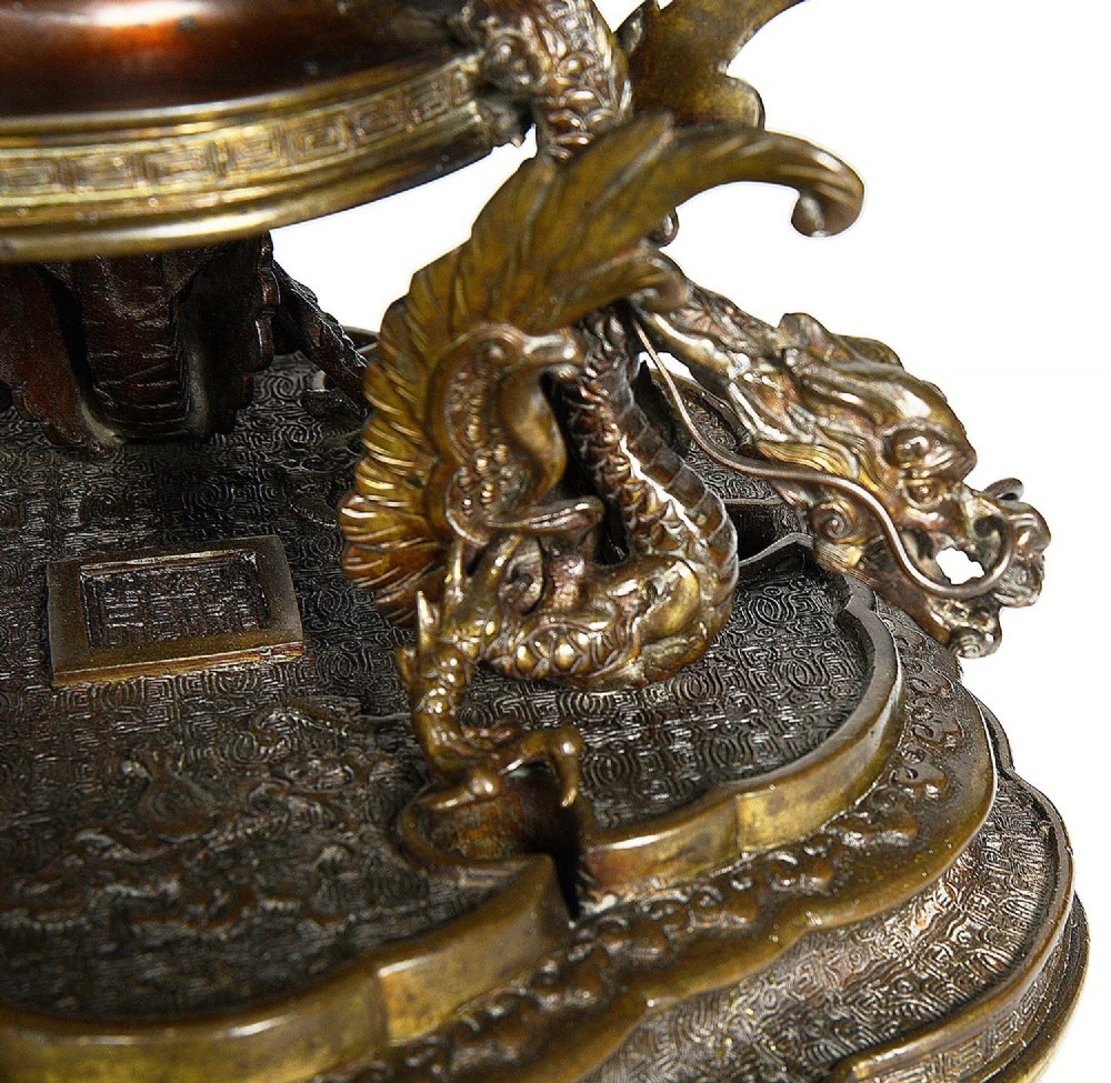 A pair of ornate antique Japanese Meiji period bronze lidded censers featuring dragon bases, relief panels, and shishi lion finials. View VI
