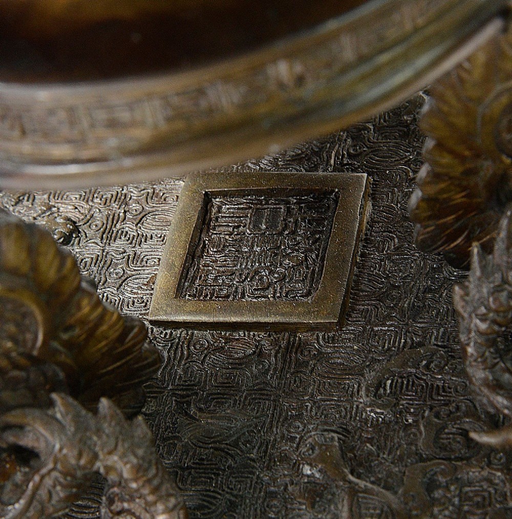 A pair of ornate antique Japanese Meiji period bronze lidded censers featuring dragon bases, relief panels, and shishi lion finials. View IX