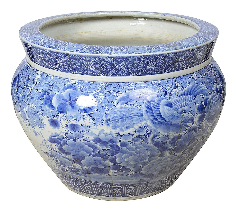 A large round Japanese blue and white porcelain jardiniere featuring intricate hand-painted floral patterns and bird motifs.