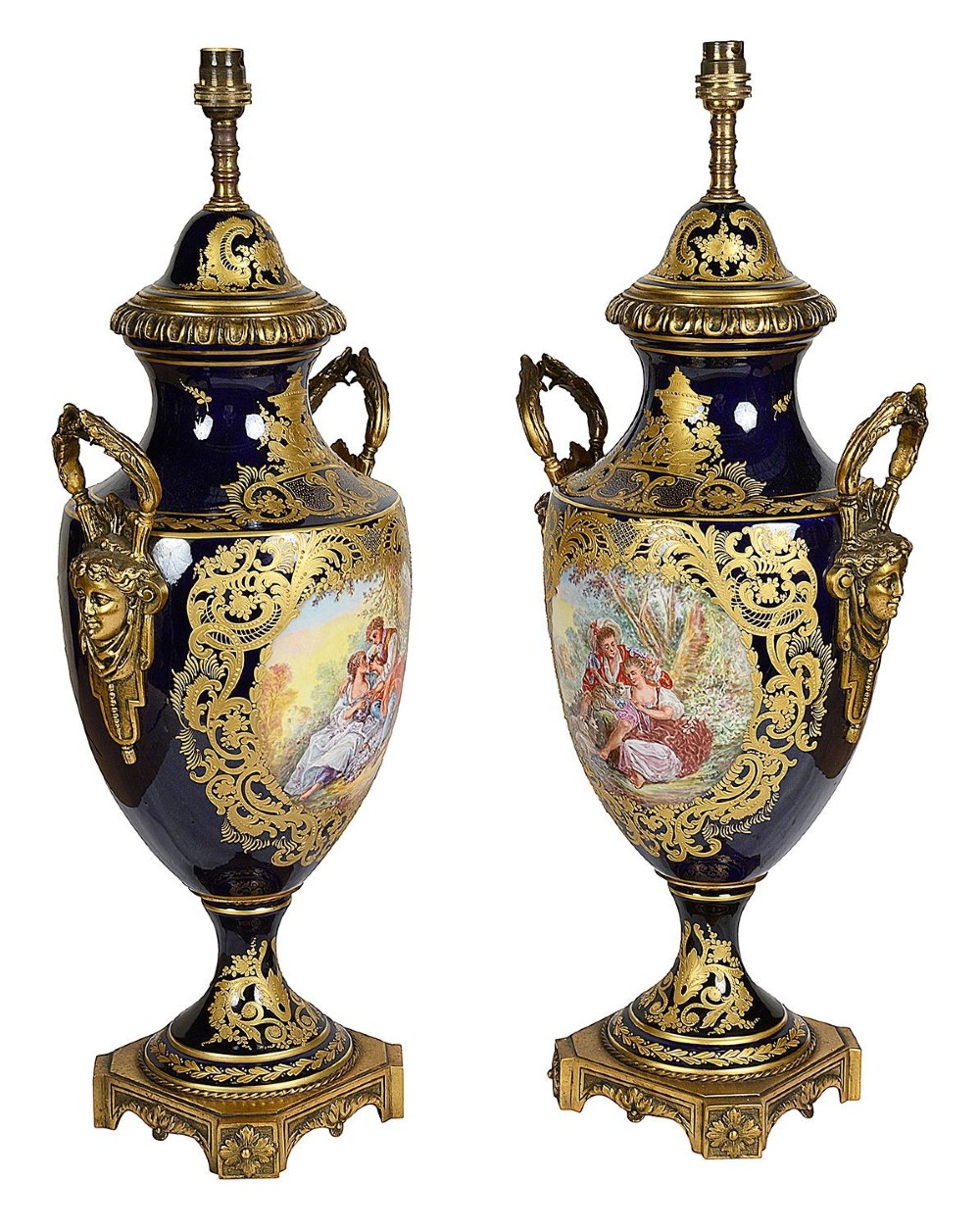 A pair of 19th-century French Sevres-style cobalt blue porcelain urn lamps featuring hand-painted romantic scenes, ornate gilt bronze mounts, and fringed fabric shades. View VIII