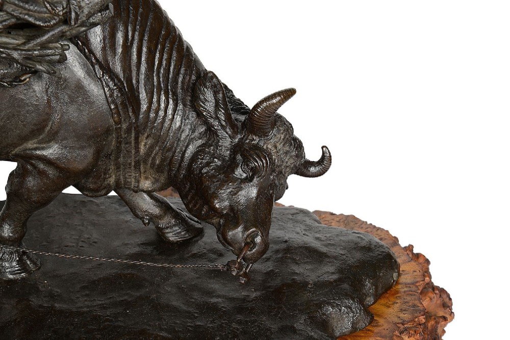 A dark patinated bronze Meiji period sculpture depicting a woodsman guiding a water buffalo laden with firewood, mounted on a rustic carved burr wood base. View II