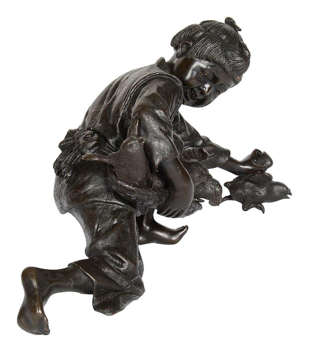 A dark brown patinated Japanese bronze sculpture depicting a crouching girl in traditional robes gathering chickens, dating to the late nineteenth century. View II
