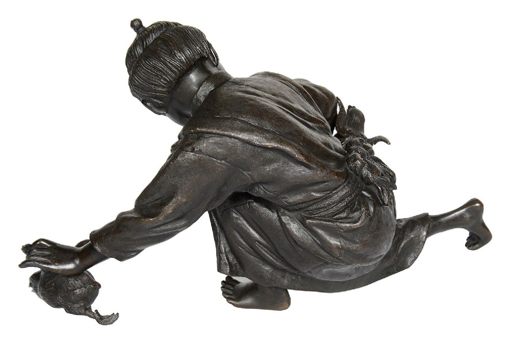 A dark brown patinated Japanese bronze sculpture depicting a crouching girl in traditional robes gathering chickens, dating to the late nineteenth century. View VI