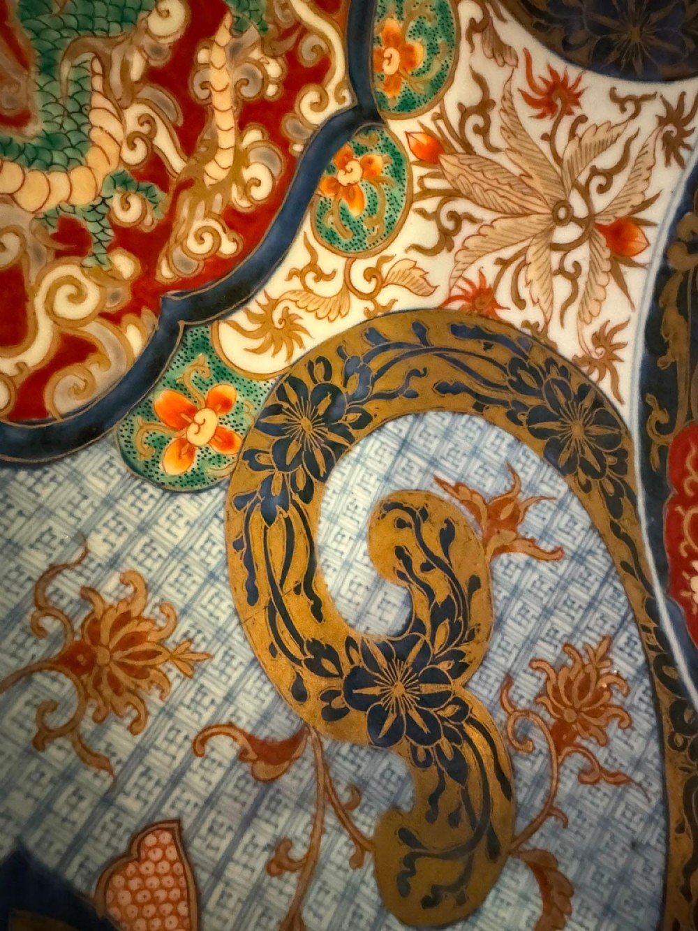 A circular 19th-century Japanese Imari porcelain charger featuring a central blue phoenix motif surrounded by intricate panels with figures, dragons, and floral patterns in blue, red, green, and gold. View IV