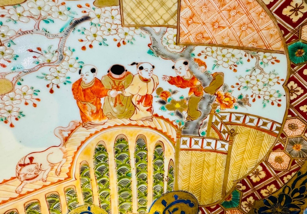 A circular 19th-century Japanese Imari porcelain charger featuring a central blue phoenix motif surrounded by intricate panels with figures, dragons, and floral patterns in blue, red, green, and gold. View V
