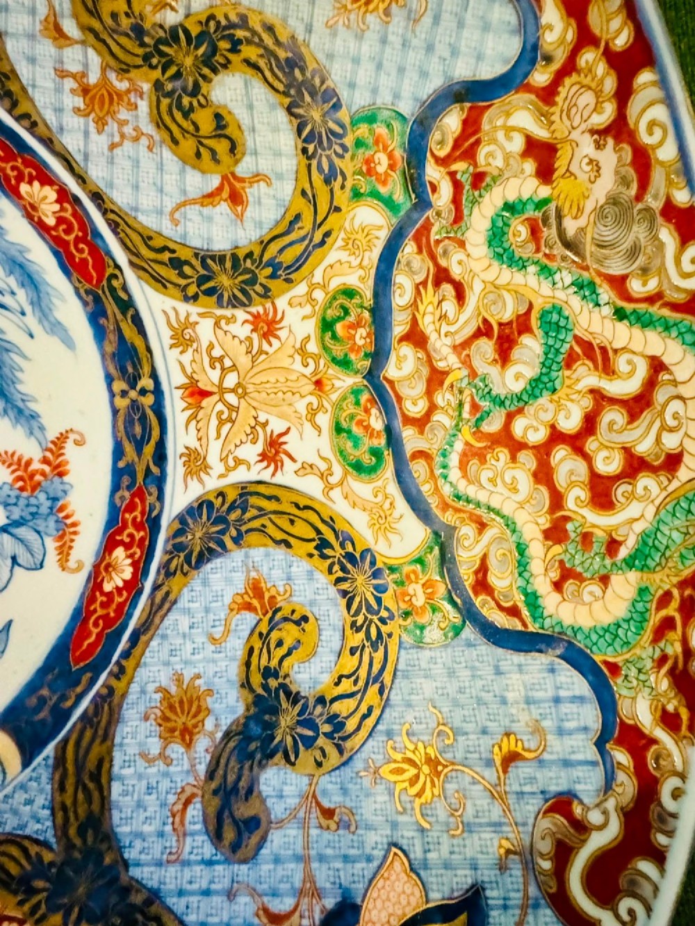 A circular 19th-century Japanese Imari porcelain charger featuring a central blue phoenix motif surrounded by intricate panels with figures, dragons, and floral patterns in blue, red, green, and gold. View VI