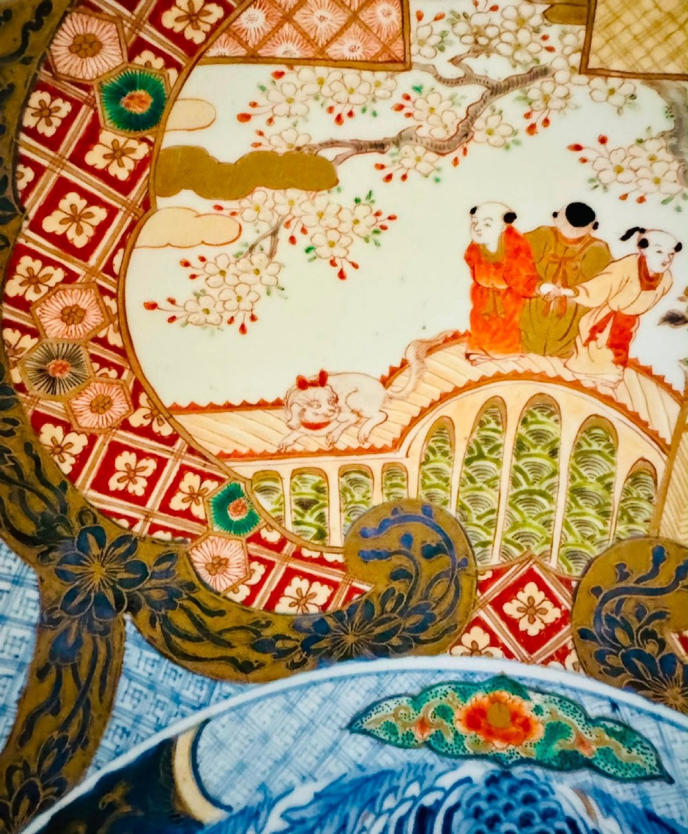 A circular 19th-century Japanese Imari porcelain charger featuring a central blue phoenix motif surrounded by intricate panels with figures, dragons, and floral patterns in blue, red, green, and gold. View VII