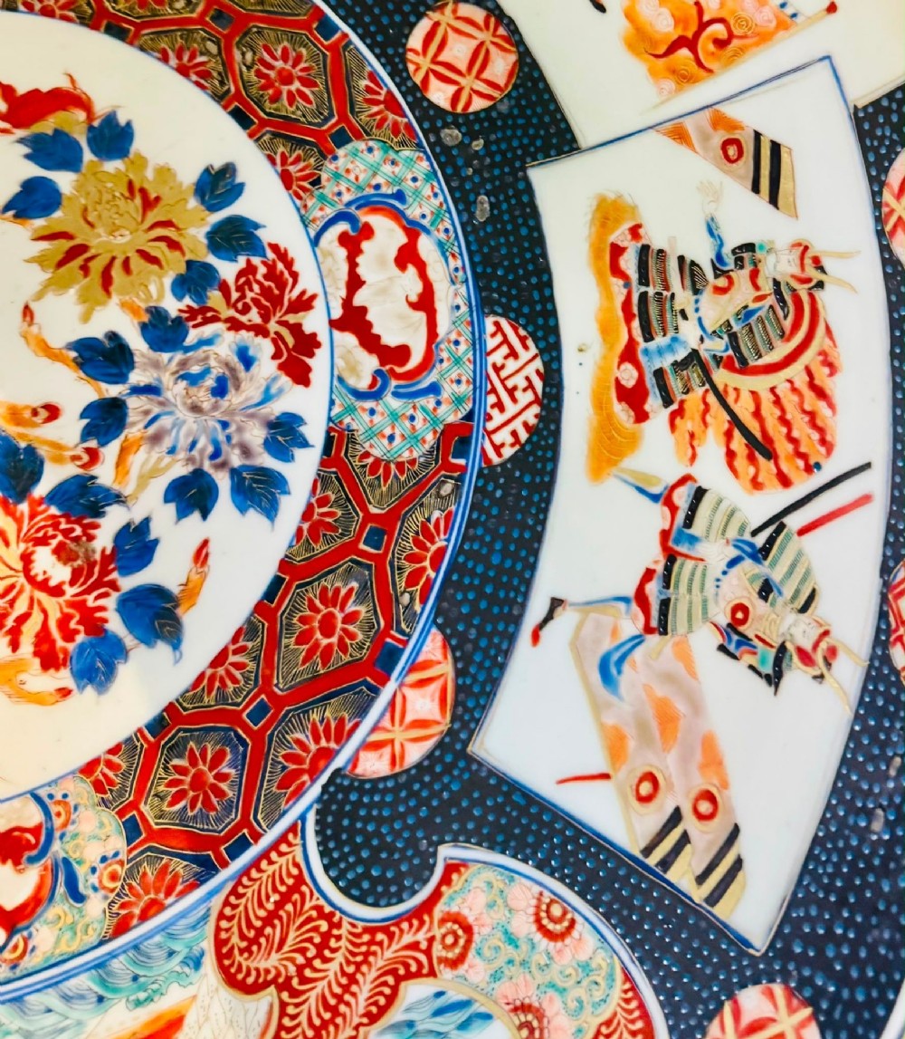 A large 19th-century Japanese Imari porcelain charger featuring hand-painted samurai panels and floral medallions in rust red, blue, and gold. View IV