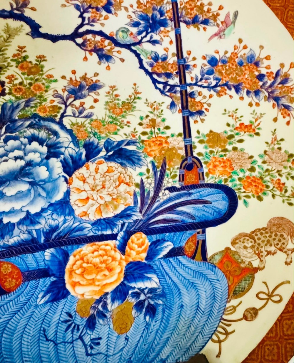 A large circular Japanese Imari porcelain charger decorated with a central blue and orange flower basket and geometric border. View V