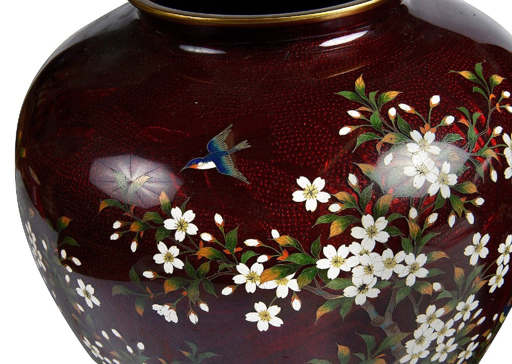 A pair of Japanese Meiji period baluster vases featuring translucent deep red enamel decorated with white blossom branches and small birds. View II
